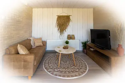 a living room with a couch and a table at Wellness Lodge aan de Braassem in Rijnsaterwoude