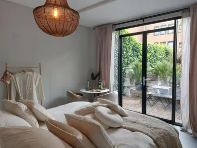 a bedroom with a large bed with a large window at Saya Boutique Hotel in Amersfoort