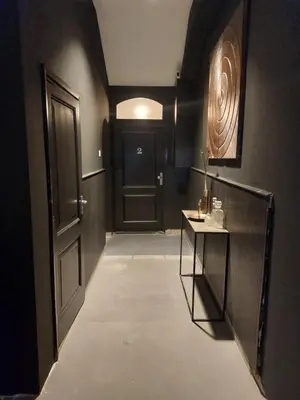 a hallway with a black door and a table at Saya Boutique Hotel in Amersfoort