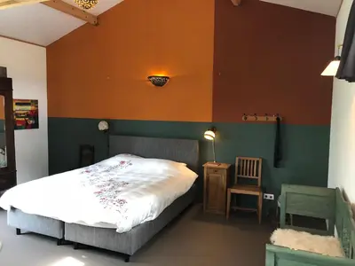 a bedroom with a bed and a table and a chair at Beautiful Countryside house, close to Amsterdam in Broek in Waterland