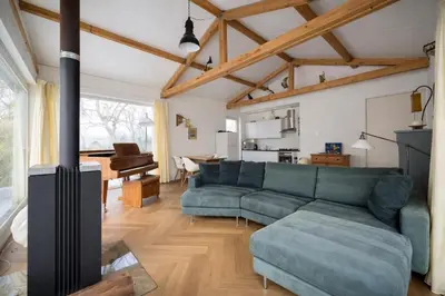 a living room with a green couch and a stove at Beautiful Countryside house, close to Amsterdam in Broek in Waterland