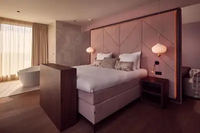 a bedroom with a large bed and a bath tub at Van der Valk Hotel Lelystad in Lelystad