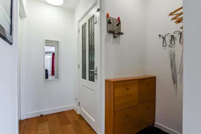 a hallway with a door and a wooden dresser at Studio Tara at the Beach with Private Parking in Zandvoort