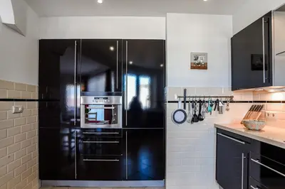 a kitchen with a black refrigerator in a kitchen at Studio Tara at the Beach with Private Parking in Zandvoort
