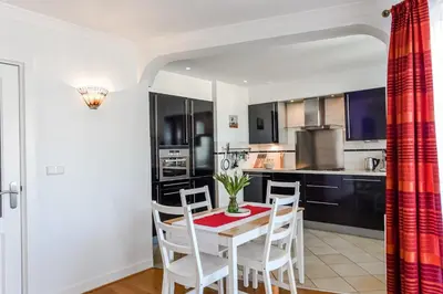 a kitchen with a table and chairs in a room at Studio Tara at the Beach with Private Parking in Zandvoort