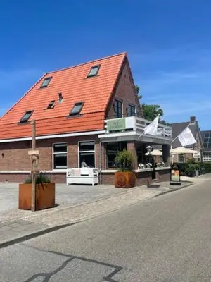 a building with an orange roof on a street at The Lake Inn in Nieuwkoop