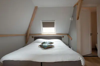 a bed in a small room with a window at The Lake Inn in Nieuwkoop