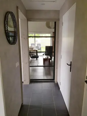 a hallway with a door leading to a living room at Luxe vakantiehuis met omheinde tuin voor hond en kinderen in Dirkshorn