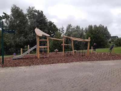 a playground in a park with a slide at Luxe vakantiehuis met omheinde tuin voor hond en kinderen in Dirkshorn