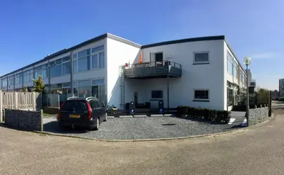 a car parked in front of a building at De Wulk 27 in Zandvoort