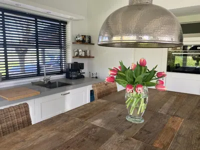 a vase of flowers on a table in a kitchen at Holidayhome Geuzenhoeve op de Munnickaij in Schellinkhout