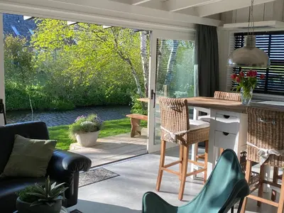 a kitchen and living room with a view of a patio at Holidayhome Geuzenhoeve op de Munnickaij in Schellinkhout