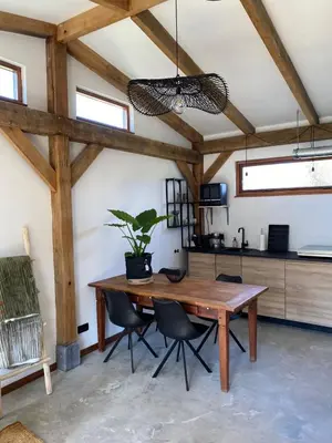 a dining room with a wooden table and chairs at Zantverde in Zandvoort