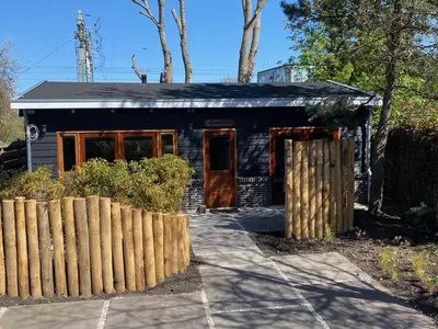 a small blue house with a fence in front of it at Zantverde in Zandvoort