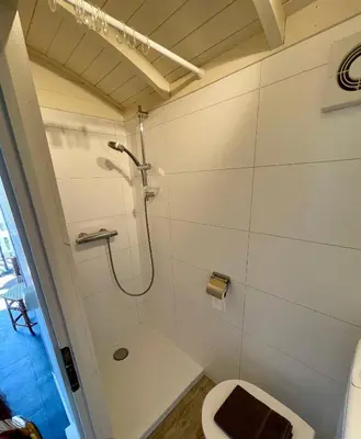 a bathroom with a shower and a toilet at Pipowagen aan zee in Bergen aan Zee