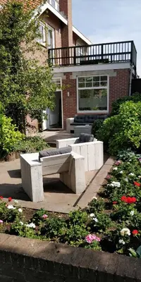 a garden with benches in front of a building at Bed & Beach 023 in Zandvoort