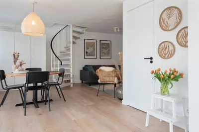 a dining room and living room with a table and chairs at Bed & Beach 023 in Zandvoort