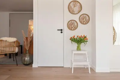 a room with a white door and a vase of flowers on a table at Bed & Beach 023 in Zandvoort