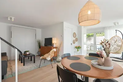 a dining room and living room with a table and chairs at Bed & Beach 023 in Zandvoort