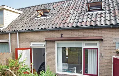 a brick house with a sliding glass door at Lovely Home In Egmond Aan Zee With Wifi in Egmond aan Zee