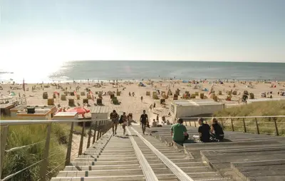 a group of people sitting on stairs at the beach at Lovely Home In Egmond Aan Zee With Wifi in Egmond aan Zee