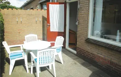 a white table and chairs on a patio with a window at Lovely Home In Egmond Aan Zee With Wifi in Egmond aan Zee