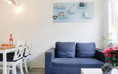 a living room with a blue couch and a table at Lovely Home In Egmond Aan Zee With Wifi in Egmond aan Zee