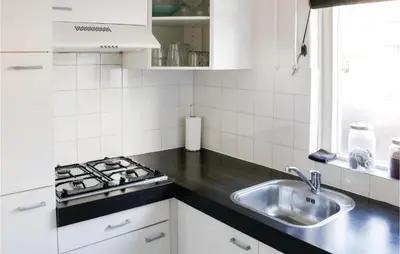 a kitchen with a sink and a stove at Lovely Home In Egmond Aan Zee With Wifi in Egmond aan Zee