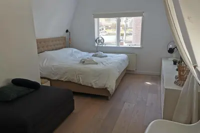 a small bedroom with a bed and a window at Sandy's Family Beach House for 2 adults & 2 children in Zandvoort