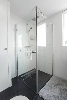 a bathroom with a shower with a glass door at Sandy's Family Beach House for 2 adults & 2 children in Zandvoort