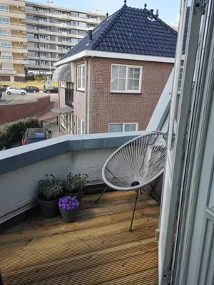 a balcony with a bench sitting on a deck at Sandy's Family Beach House for 2 adults & 2 children in Zandvoort