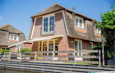 a brick house with a fence in front of it at Holiday Home Breukelen in Breukelen