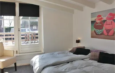 a bedroom with a bed and a chair and a window at Holiday Home Breukelen in Breukelen