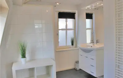 a white bathroom with a sink and a mirror at Holiday Home Breukelen in Breukelen