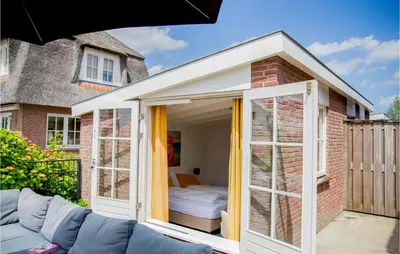 a large whiteconservatory with a couch on a patio at Holiday Home Breukelen in Breukelen