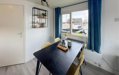 a dining room with a table and a window at Chalet in Breukelen