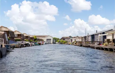 a canal in a town with houses and buildings at Chalet in Breukelen