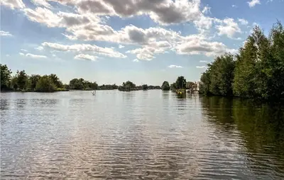 a view of a river with trees and a cloudy sky at Holiday Home Breukelen Iv in Breukelen