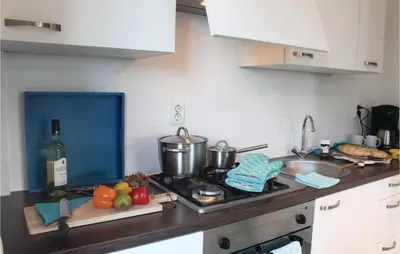 a kitchen with a counter with a sink and a stove at Holiday Home Breukelen Iv in Breukelen
