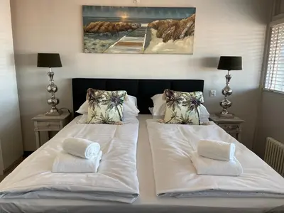 a bedroom with two beds with white sheets and pillows at Apartment Pascalle in Zandvoort