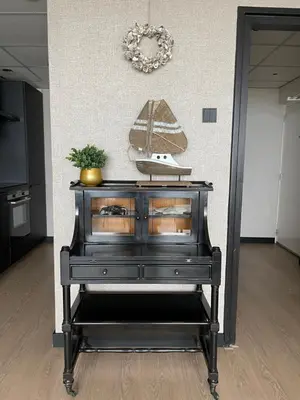 a black dresser with a model of a boat on it at Apartment Pascalle in Zandvoort