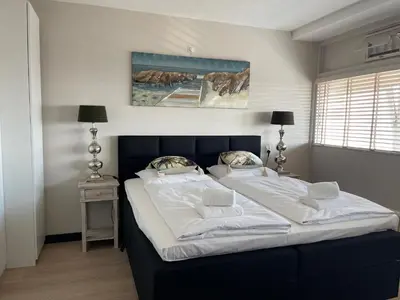 a bedroom with a large bed with white sheets and pillows at Apartment Pascalle in Zandvoort