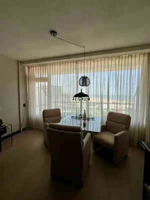 a living room with a glass table and chairs at Apartment Pascalle in Zandvoort
