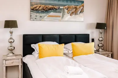 a bedroom with a bed with yellow pillows at Apartment Pascalle in Zandvoort
