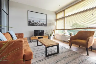 a living room with a couch and a table and a tv at Shell 51 in Zandvoort