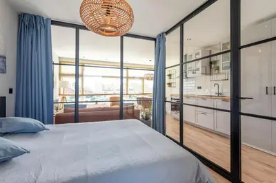 a bedroom with a large bed and a kitchen at Shell 51 in Zandvoort