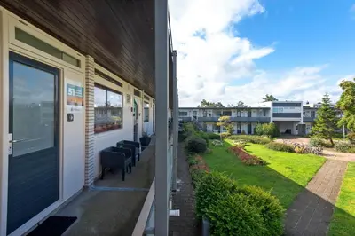 a porch of a house with chairs and a yard at Shell 51 in Zandvoort