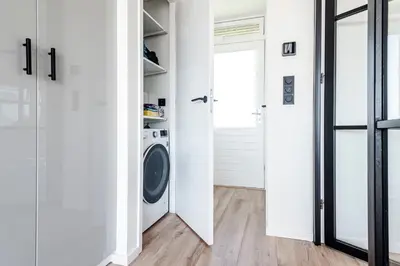 a white laundry room with a washer and dryer at Shell 51 in Zandvoort