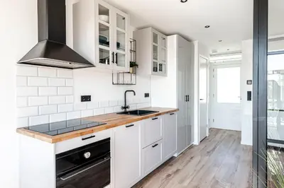 a kitchen with white cabinets and a sink at Shell 51 in Zandvoort