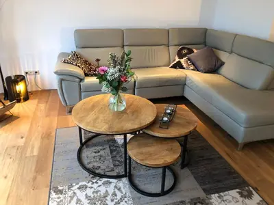 a living room with a couch and two tables at Guesthouse BedNboot met terras aan het water in Rijpwetering